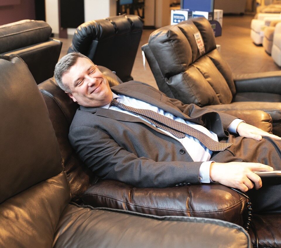 Darvin President Will Harris testing a recliner, one the company's large selection of "motion" furniture.
